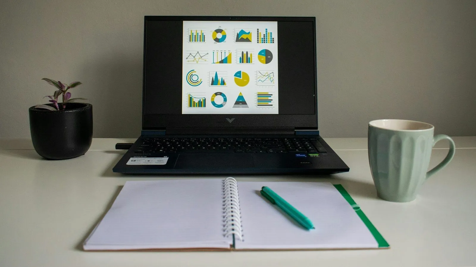 Laptop, open notebook and a mug on a tidy desk while the GST return is prepared